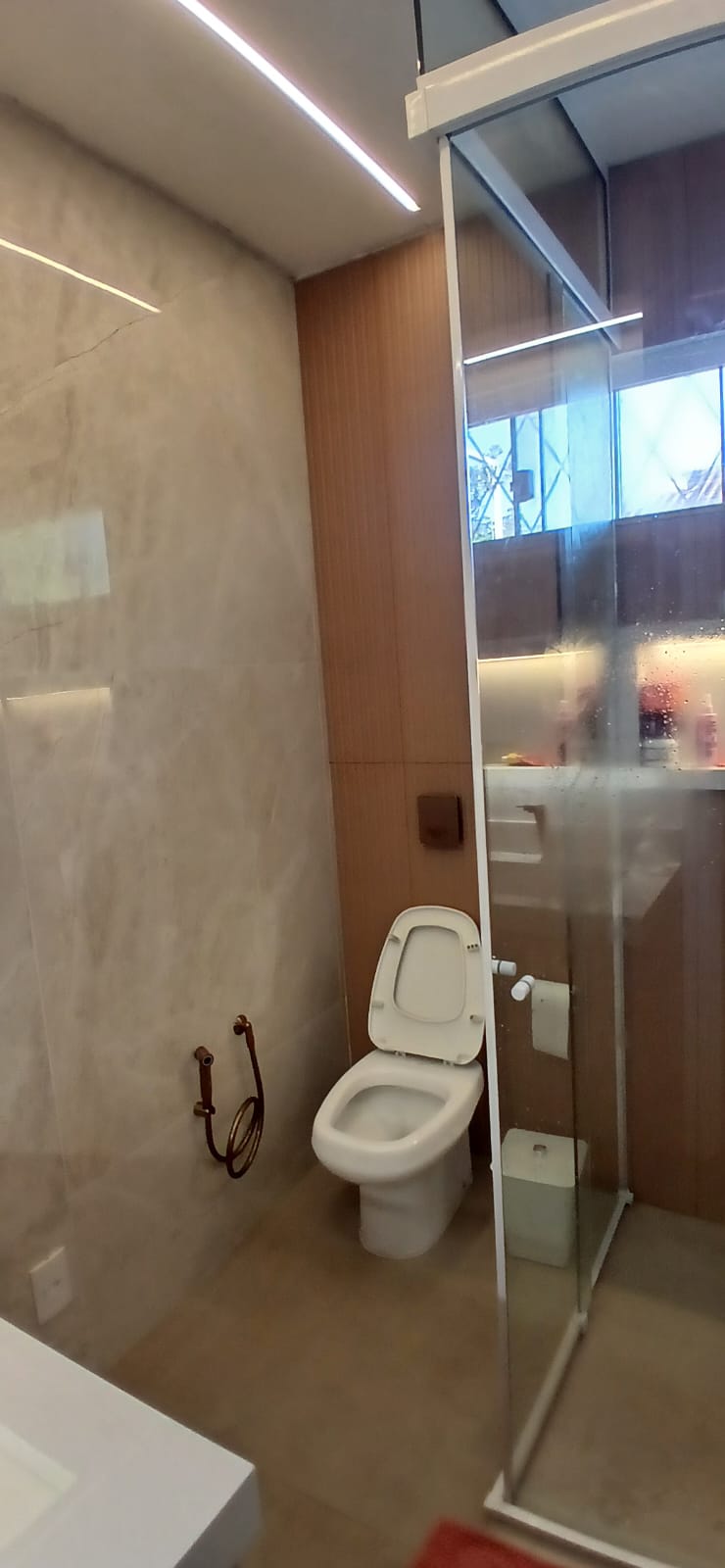 Banheiro pequeno recém-reformado com porcelanato claro, box de vidro temperado e bancada em quartzo branco Banheiro pequeno recém-reformado com porcelanato claro, box de vidro temperado e bancada em quartzo branco